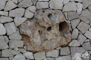 Pietra con fori naturali incastonata nel muro e predisposta per alloggiarvi corpi illuminanti